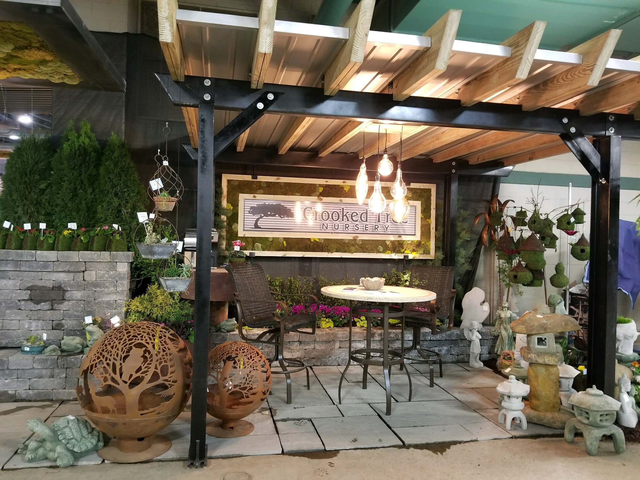 a patio covered in lots of plants and furniture.