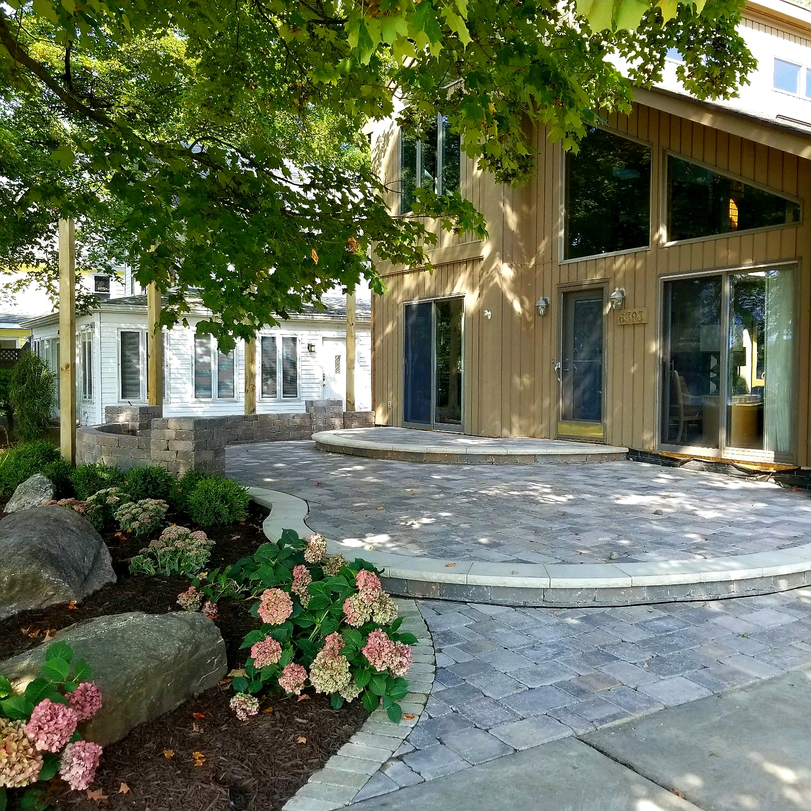 a house with a stone patio and landscaping.