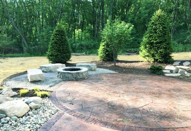 a stone patio surrounded by trees and rocks.