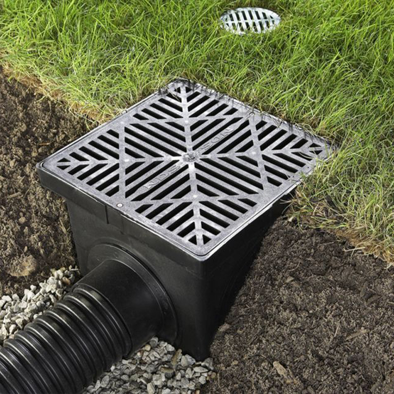 a drain in the ground next to a drainage pipe.