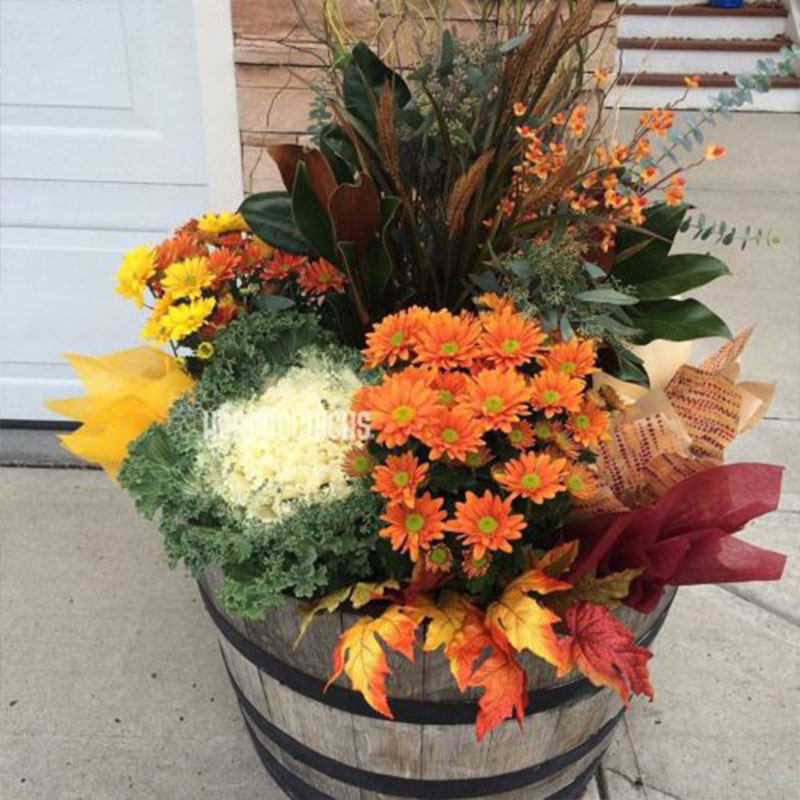 a wooden barrel filled with lots of colorful flowers.