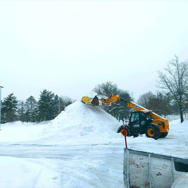 a bulldozer digging through a pile of snow.